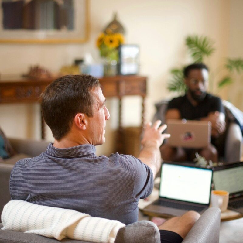 man in gray sweater sitting on couch