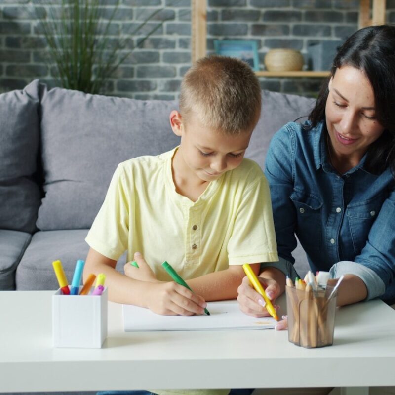 Mother and son drawing together at a table